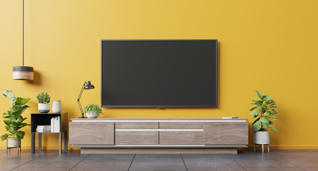 TV on cabinet in modern living room on yellow wall background,3d rendering