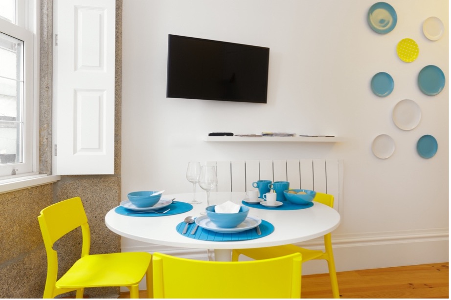 A table with blue plates and yellow chairs