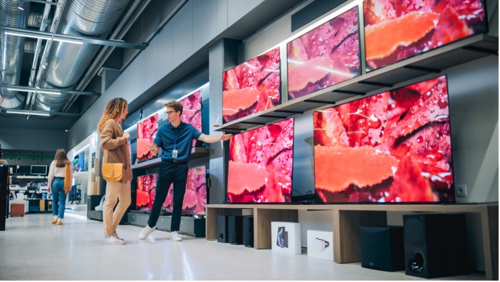 Two people looking at televisions