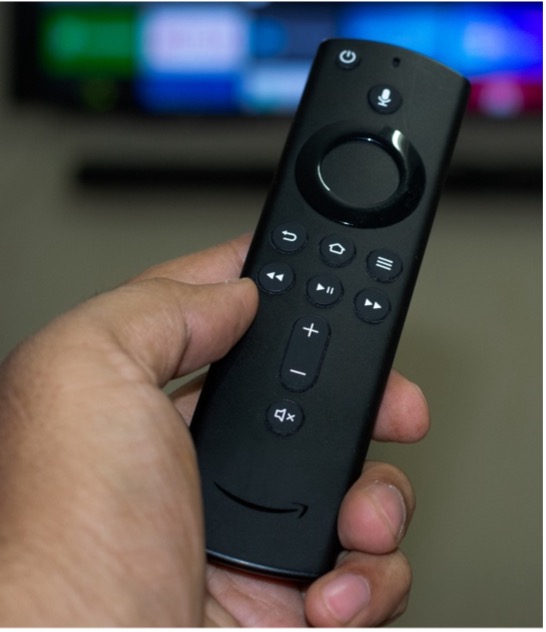 A hand holding a remote control